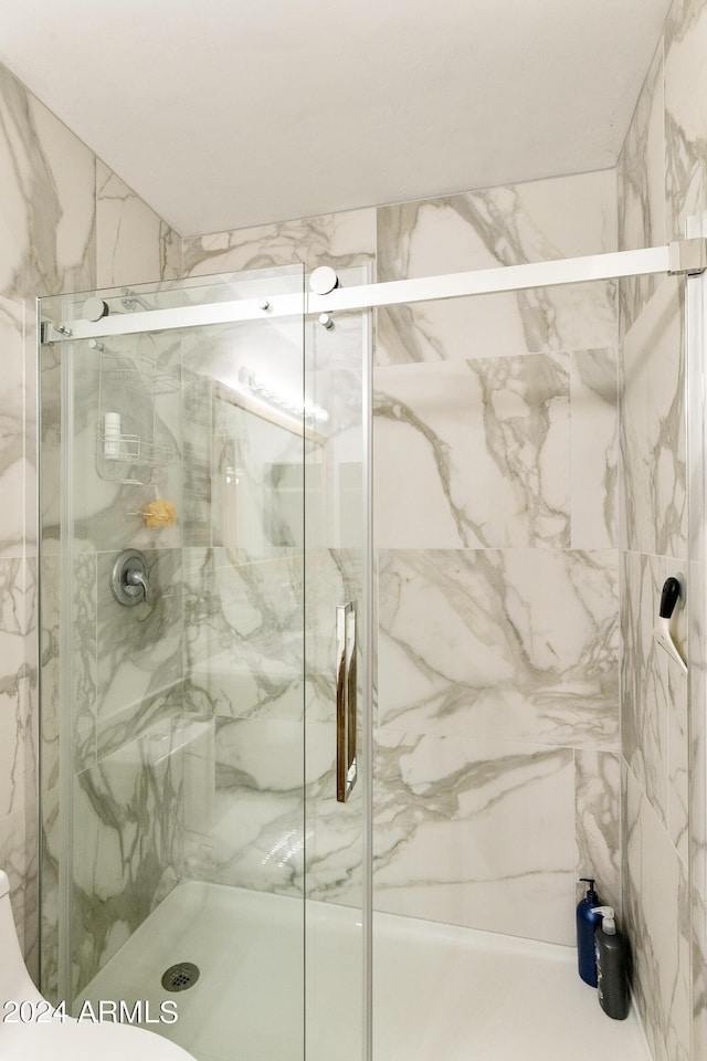 bathroom featuring a marble finish shower