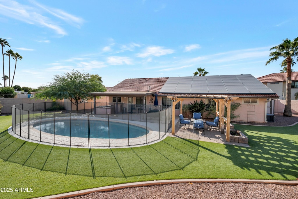 view of pool featuring a hot tub, a patio area, and a lawn