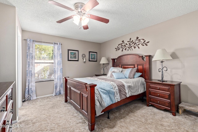 bedroom with light carpet, ceiling fan, and a textured ceiling