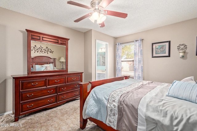 bedroom with ceiling fan, connected bathroom, light carpet, and a textured ceiling