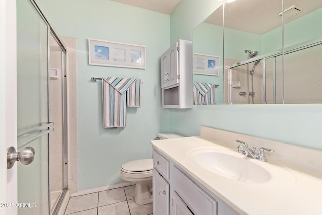 bathroom with vanity, a shower with door, tile patterned floors, and toilet