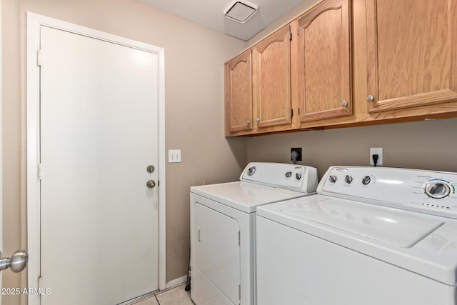 clothes washing area featuring light tile patterned flooring, cabinets, and washing machine and dryer