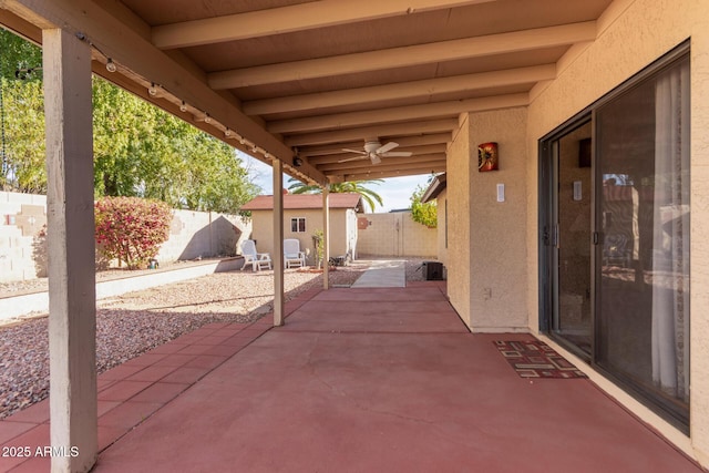 view of patio with ceiling fan and a storage unit