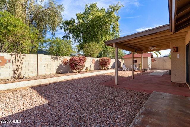 view of yard with ceiling fan and a patio area