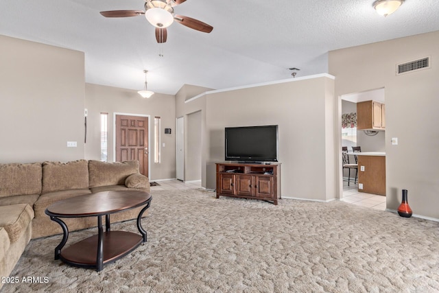 living room with ceiling fan, light carpet, and a textured ceiling