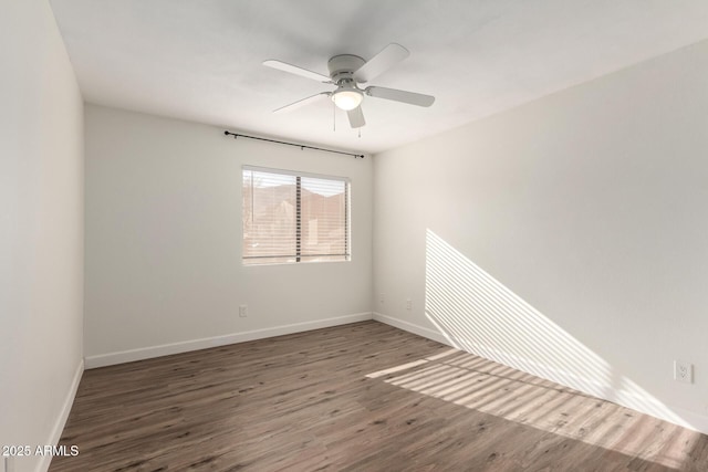 spare room featuring ceiling fan and dark hardwood / wood-style flooring