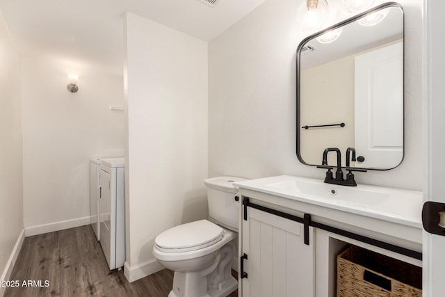 bathroom with separate washer and dryer, vanity, hardwood / wood-style flooring, and toilet