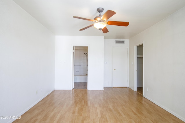 unfurnished bedroom featuring ensuite bath, visible vents, light wood-type flooring, and baseboards