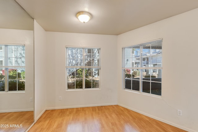 empty room with baseboards and light wood-style floors