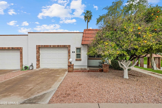 view of front of home featuring a tile roof, a garage, and driveway