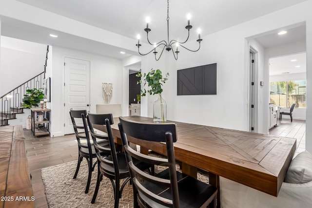 dining area featuring a notable chandelier, stairs, wood finished floors, and recessed lighting