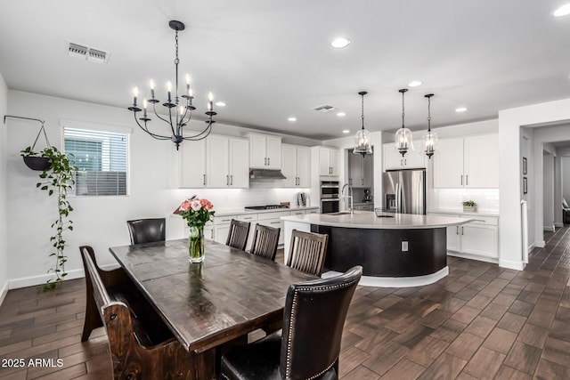 dining area with visible vents, dark wood finished floors, baseboards, and an inviting chandelier