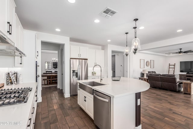 kitchen with visible vents, open floor plan, dark wood-type flooring, stainless steel appliances, and a sink