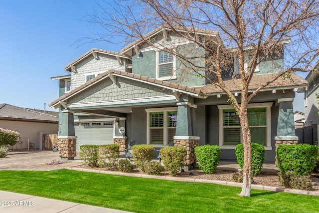 craftsman house with driveway, a garage, stone siding, stucco siding, and a front yard