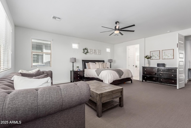 carpeted bedroom with a ceiling fan, visible vents, and ensuite bath