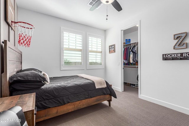 carpeted bedroom with a walk in closet, a closet, visible vents, ceiling fan, and baseboards