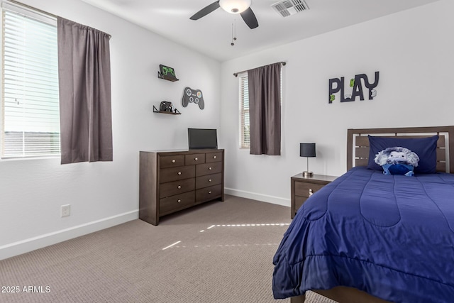 carpeted bedroom with visible vents, baseboards, and multiple windows