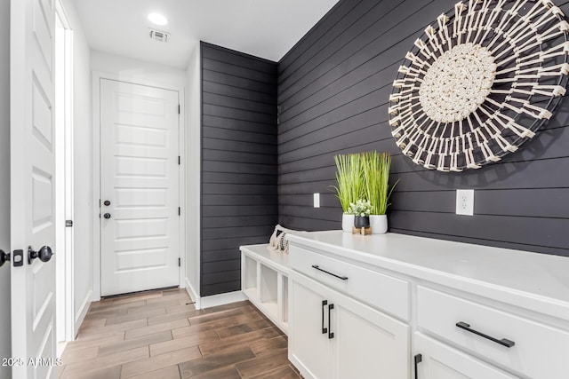 interior space featuring wood tiled floor, visible vents, and baseboards