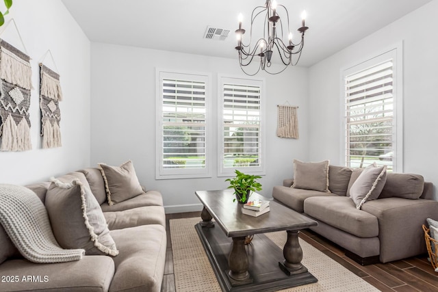 living room featuring a chandelier, dark wood finished floors, visible vents, and baseboards