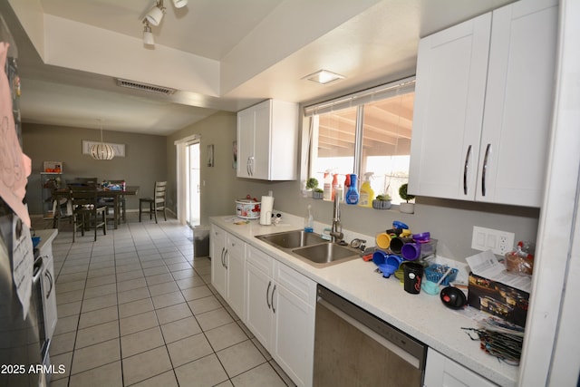 kitchen featuring visible vents, dishwasher, light countertops, light tile patterned floors, and a sink