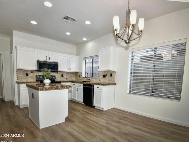 kitchen featuring hanging light fixtures, white cabinetry, a center island, and black appliances