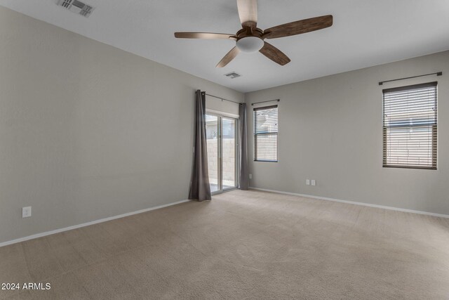 spare room with light colored carpet and ceiling fan