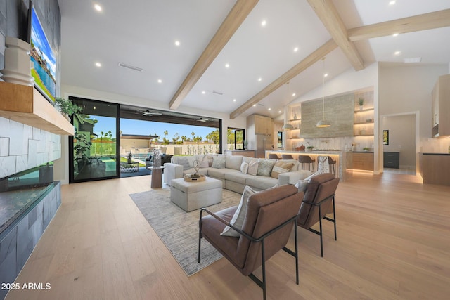 6126 E Charter Oak Rd, Scottsdale, AZ 85254 - living area with beamed ceiling, light wood-style floors, high vaulted ceiling, and a fireplace
