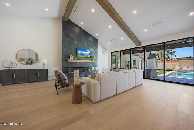 6126 E Charter Oak Rd, Scottsdale, AZ 85254 - living area with high vaulted ceiling, beamed ceiling, wood finished floors, and a fireplace