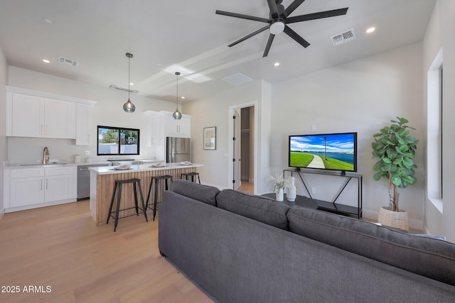 6126 E Charter Oak Rd, Scottsdale, AZ 85254 - living room with light wood finished floors, ceiling fan, and recessed lighting