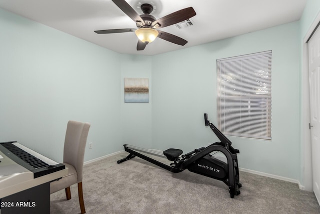 workout area featuring light carpet and ceiling fan