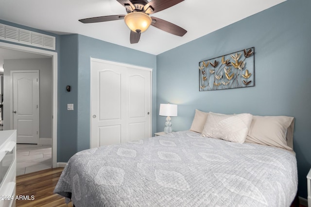 bedroom featuring dark hardwood / wood-style floors, ceiling fan, and a closet