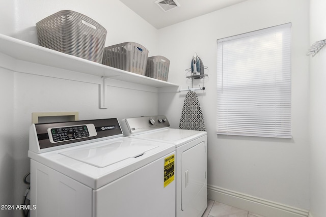 laundry room with washer and clothes dryer and light tile patterned flooring