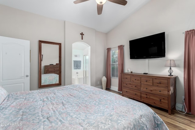 bedroom with ensuite bathroom, ceiling fan, vaulted ceiling, and light wood-type flooring