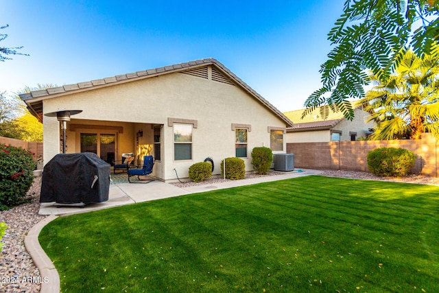 rear view of house with a lawn, a patio area, and cooling unit