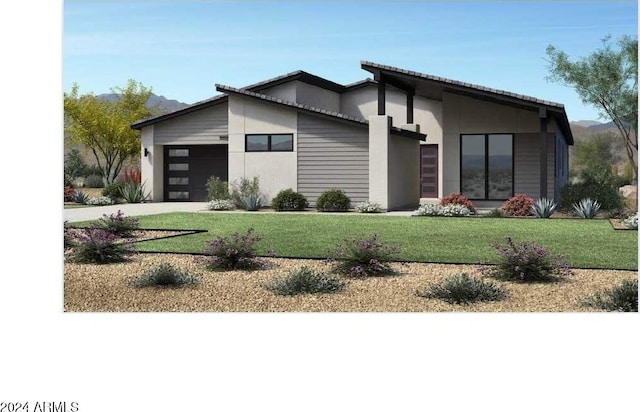 view of front of home featuring a front lawn, a garage, and driveway