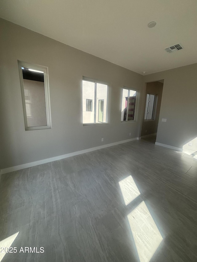 unfurnished room featuring baseboards and visible vents