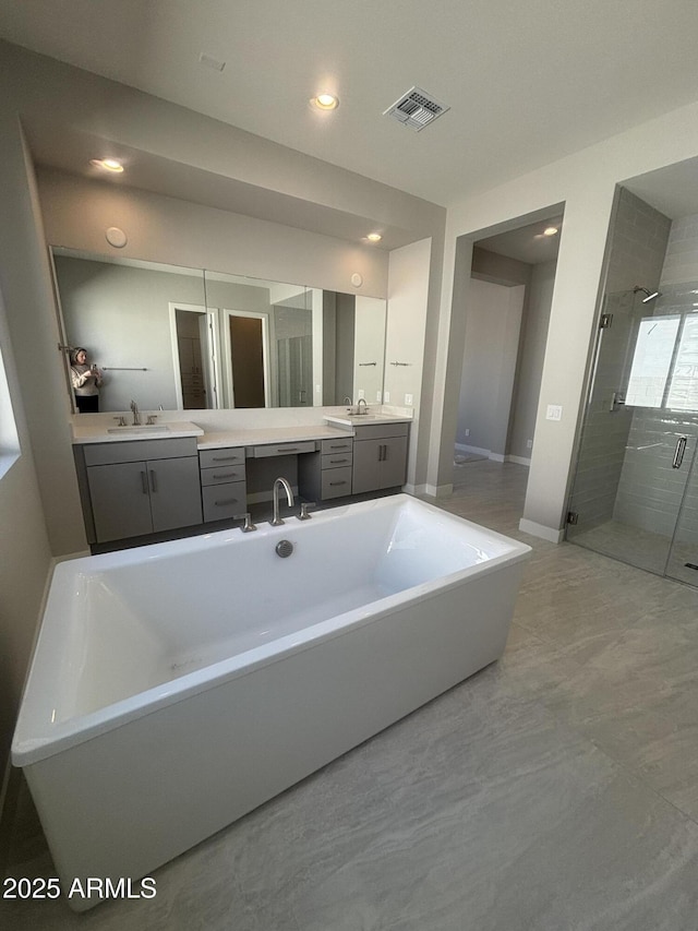 bathroom with visible vents, a shower stall, baseboards, a freestanding tub, and vanity