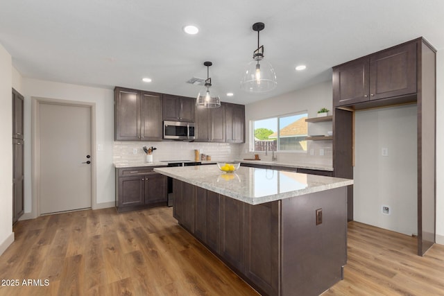 kitchen with pendant lighting, a center island, and dark brown cabinets