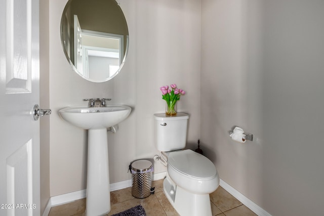 bathroom featuring toilet, sink, and tile patterned flooring