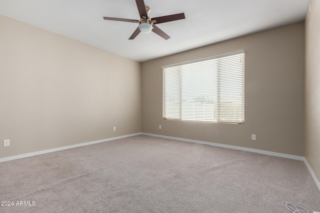 carpeted spare room featuring ceiling fan