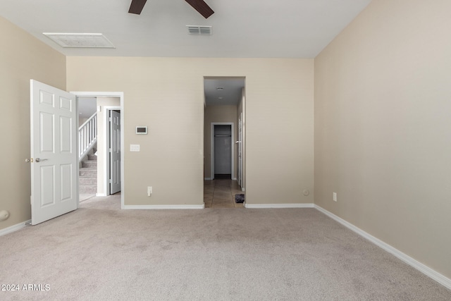 empty room featuring ceiling fan and light colored carpet