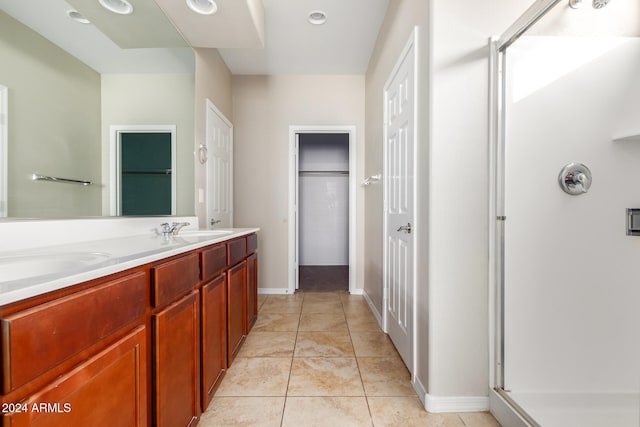 bathroom featuring vanity, a shower with shower door, and tile patterned flooring