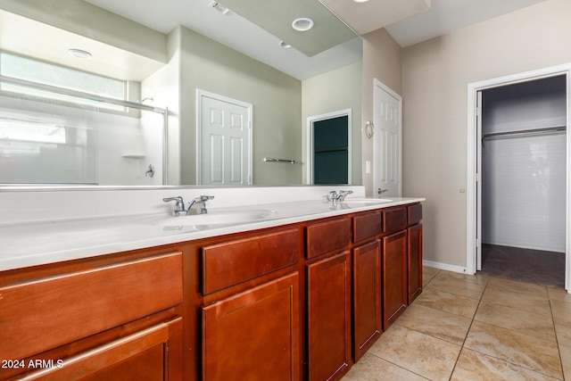 bathroom featuring vanity, a shower with door, and tile patterned flooring