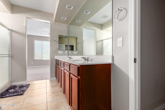 bathroom featuring vanity, a shower with shower door, and tile patterned floors