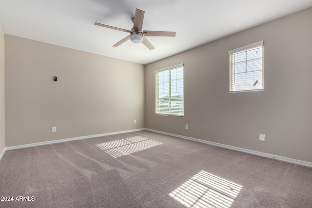 spare room featuring light carpet, plenty of natural light, and ceiling fan