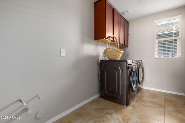 clothes washing area with cabinets and independent washer and dryer