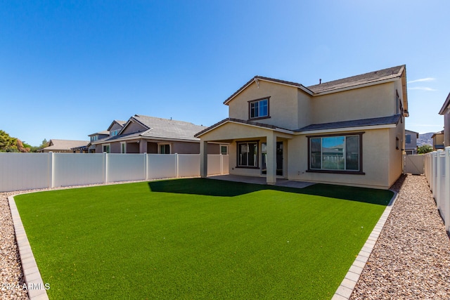 back of property featuring a patio area and a yard