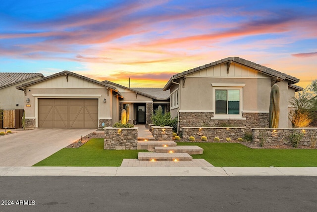 view of front of property with a garage and a lawn