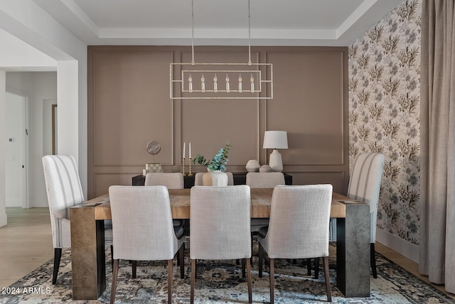 dining space with hardwood / wood-style flooring and a raised ceiling