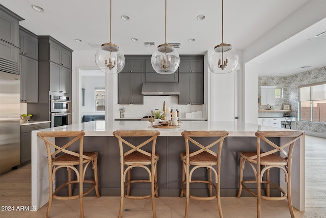 kitchen featuring hanging light fixtures, appliances with stainless steel finishes, and gray cabinetry